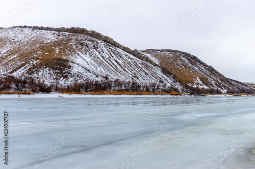 Two rocky hills on the shore of the winter frozen river. Two Sisters mountain, Belaya Kalitva town, Seversky Donets river, Russia photo