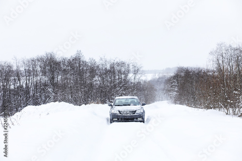 The car stands on a snow-covered road
