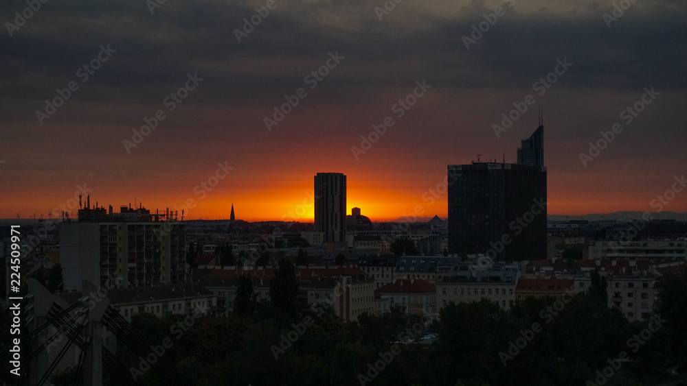 View of city buildings against cloudy sky during sunrise in Vienna / Spittelau on a summer morning