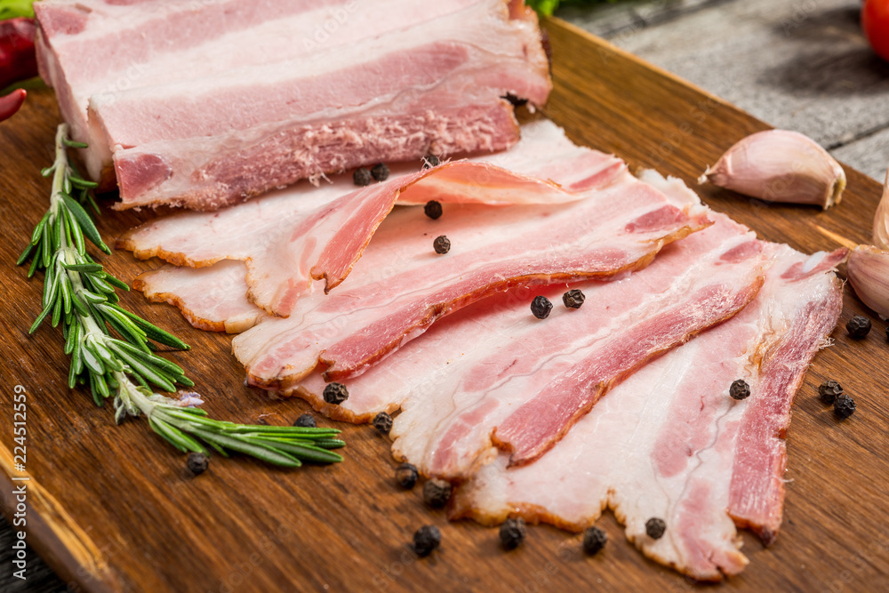 Slices of bacon on the wooden background