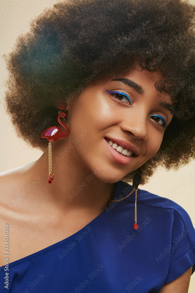 A close up portrait of a young African lady with short curly hair. The  pretty girl