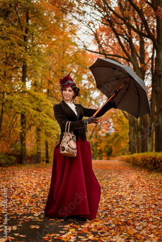 Beautiful woman dancing with umbrella in the park