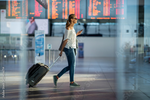 Young woman with her luggage at an international airport, before going through the check-in and the security check before her flight photo