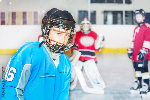 Junior hockey player in safety helmet and uniform