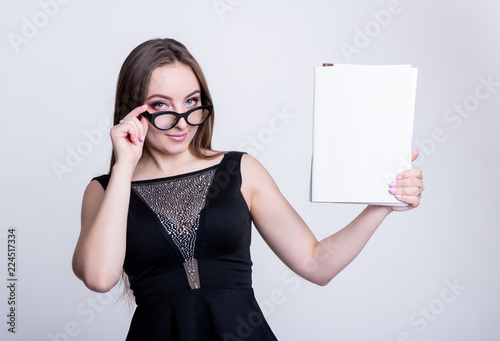 girl in glasses in a black dress with folders on a white background, office worker