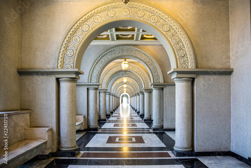 Beautiful walkway.  Building with many columns . 