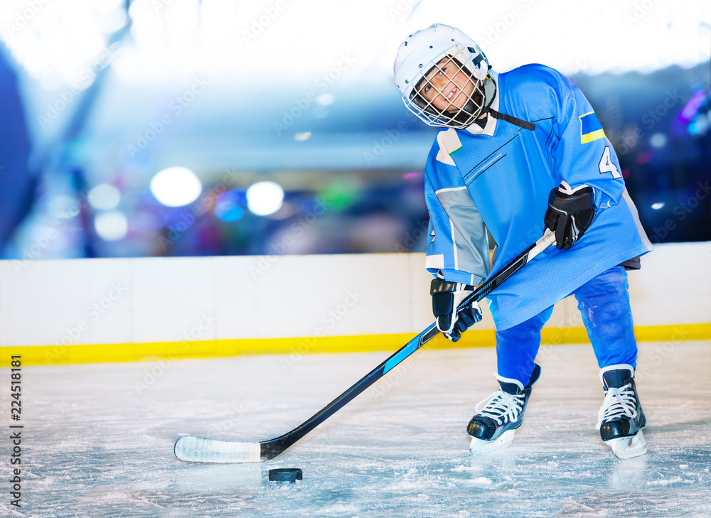 Fototapeta premium Happy little hockey player passing the puck