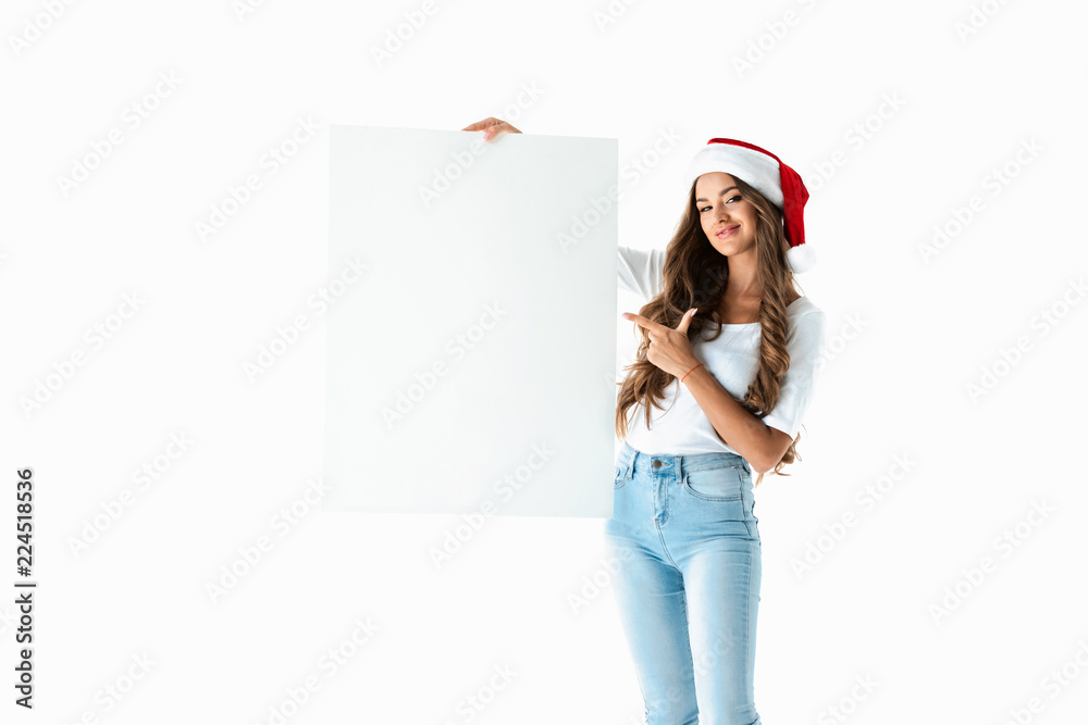 smiling girl in santa hat pointing at blank empty board, isolated on white smiling girl in santa hat pointing at blank empty board, isolated on white
