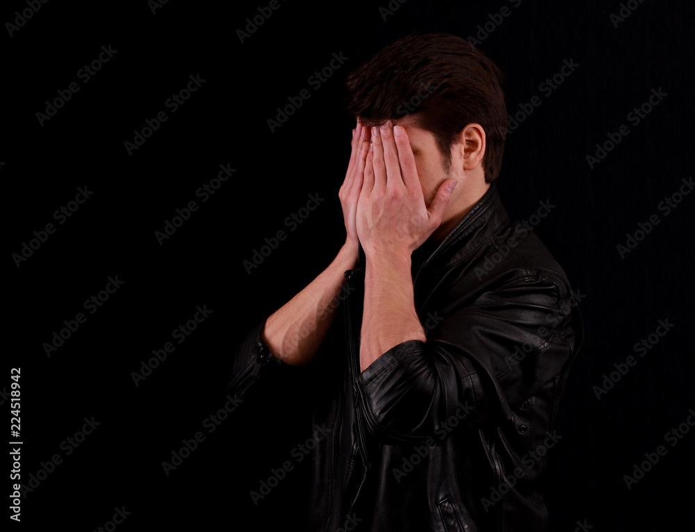 Man hiding his face on black background Man hiding his face on black background