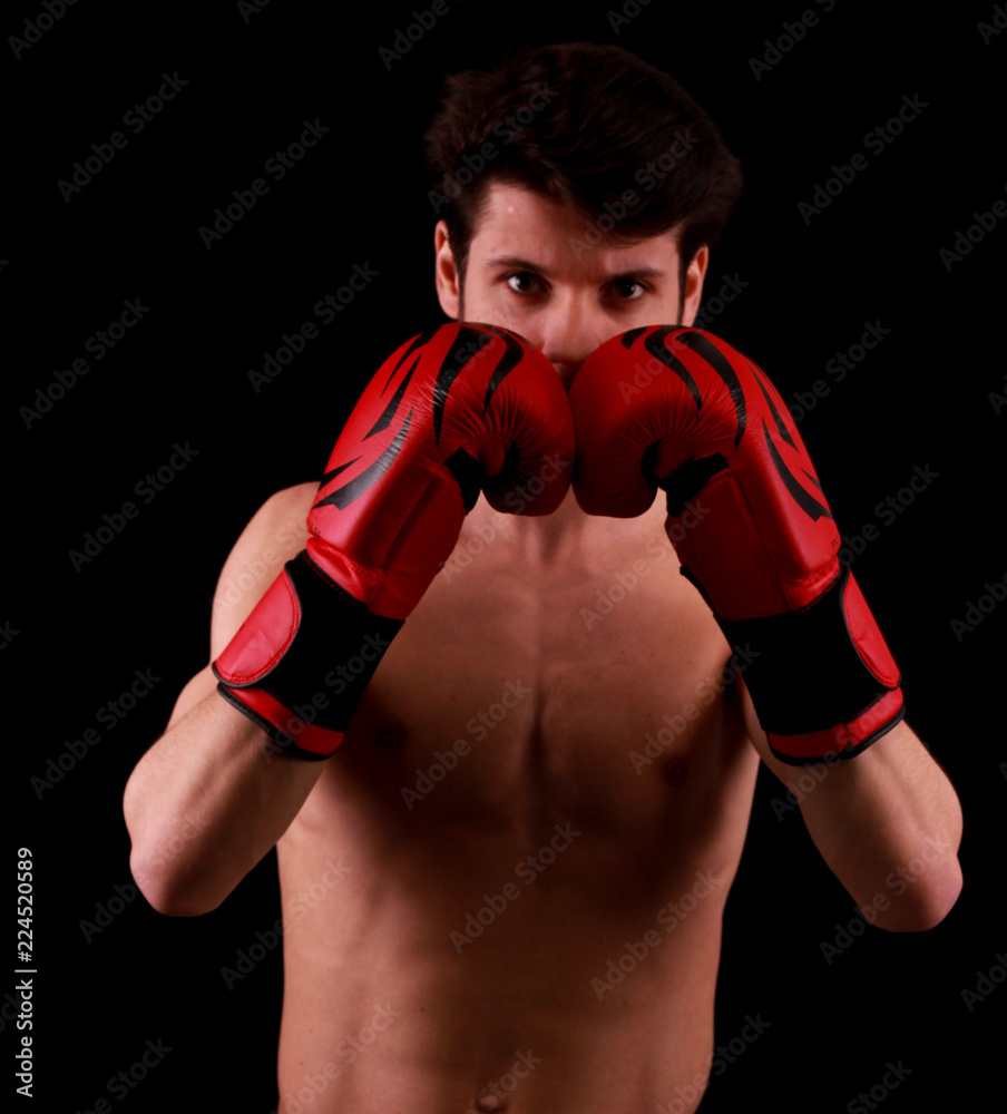 Sportsman Muay Thai boxer celebrating flawless victory in boxing cage. Isolated on black background