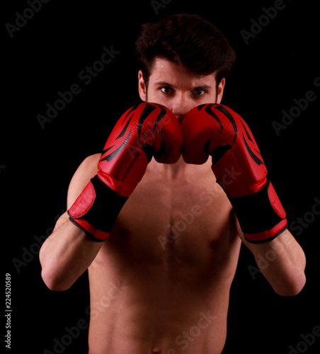 Sportsman Muay Thai boxer celebrating flawless victory in boxing cage. Isolated on black background © buraktumler