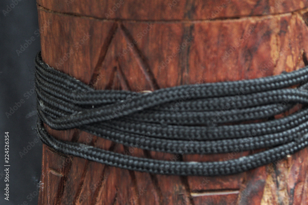 up-close view of a wooden African djembe design with tuning ropes 