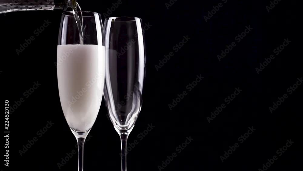 Two glasses of champagne with bottle on black background. Close up. Two glasses of champagne with bottle on black background. Close up.