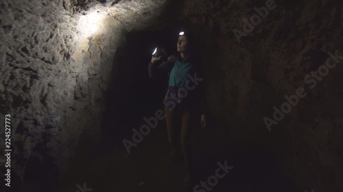 portrait of a girl, the tourist, the researcher goes into the cave with a flashlight