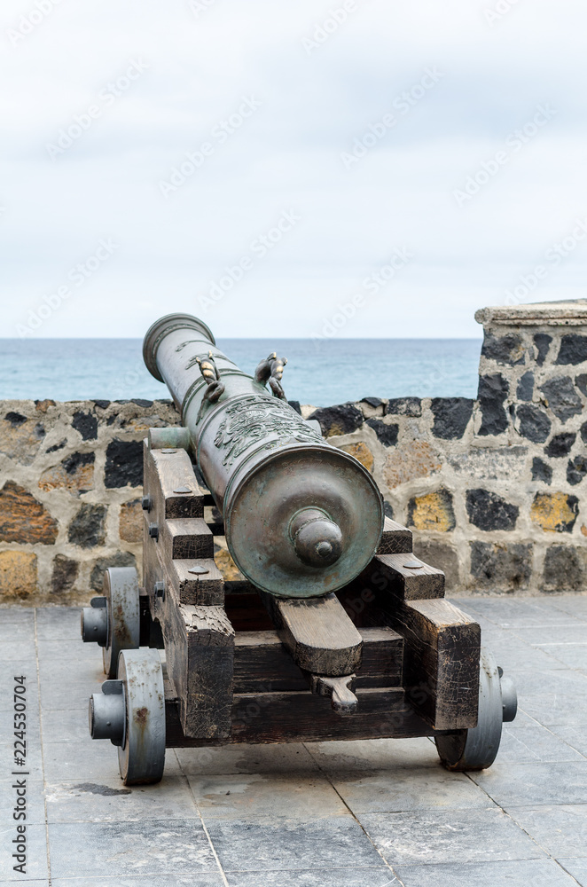 old historic cannon in front of the harbour wall