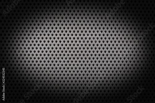 close up on a metalic shhet texture with small holes and shades.