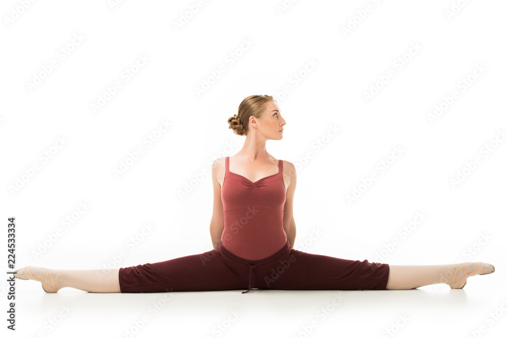 Fototapeta premium focused ballerina exercising and doing twine isolated on white background