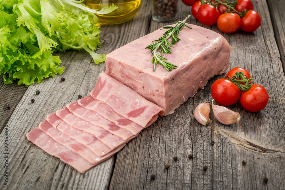 Cut sausage from ham on a wooden background Cut sausage from ham on a wooden background
