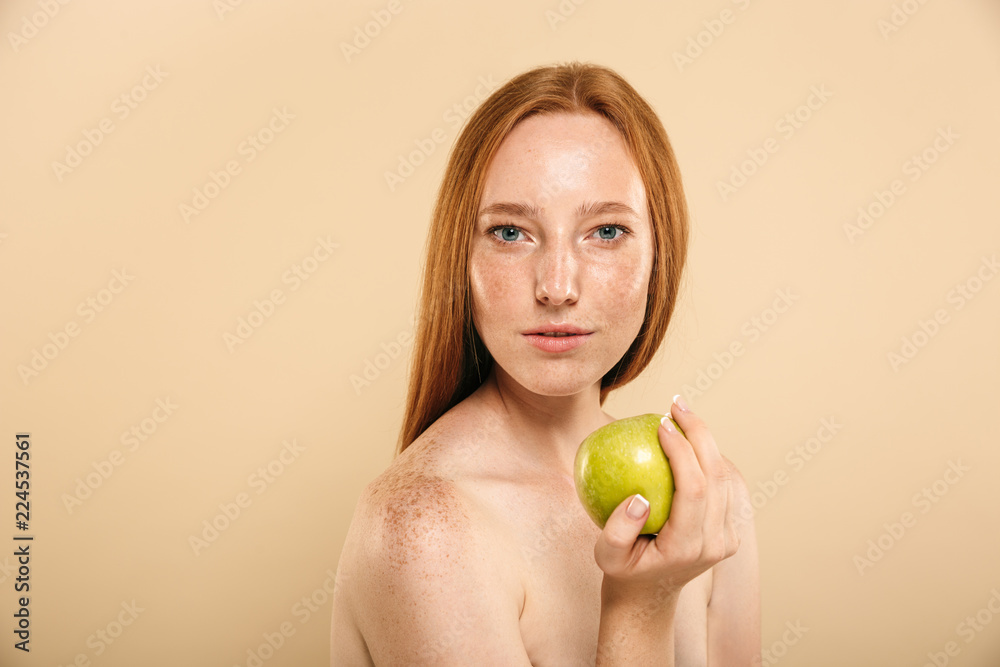 Redhead woman holding apple looking camera. Redhead woman holding apple looking camera.