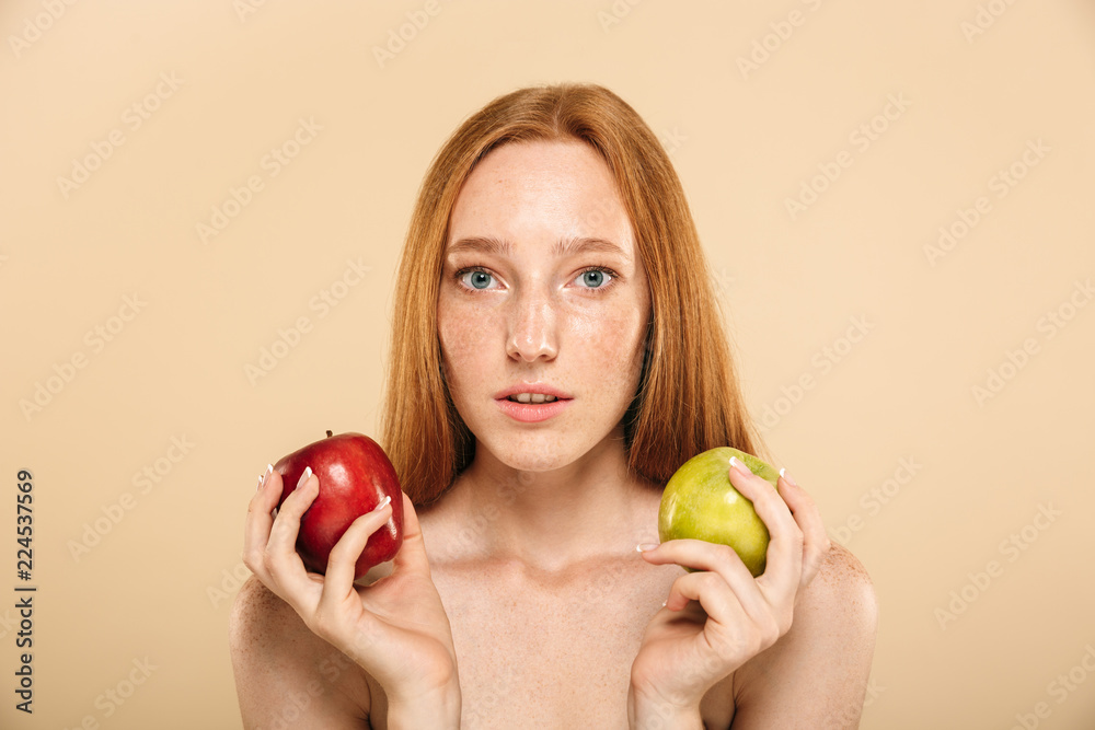 Pretty young redhead woman holding apple looking camera. Pretty young redhead woman holding apple looking camera.