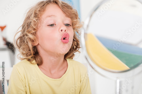 Kid learning to speech in front of window during correct pronunciation classes photo