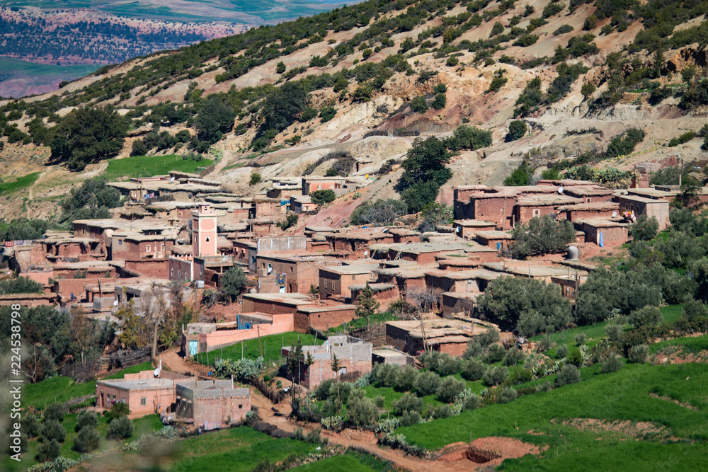 A small settlement in the Atlas Mountains. The mountain range is covered with bright green vegetation. Africa Morocco