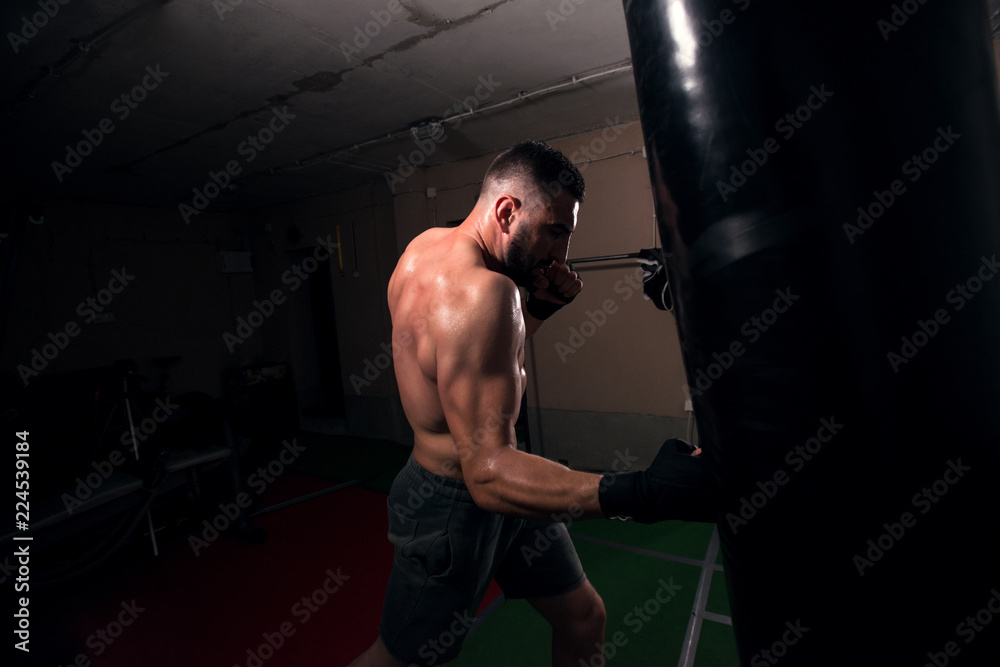 Hitting hard, boxer striking the punching bag