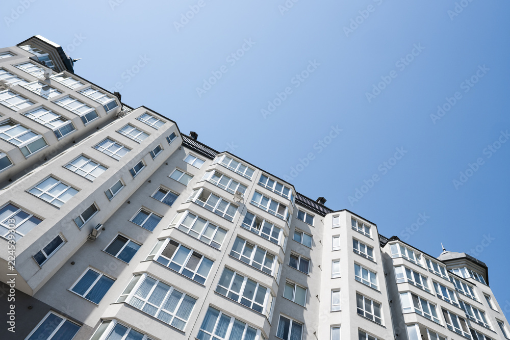 Fototapeta premium Modern and new apartment building. Multistoried, modern, new and stylish living block of flats. Real estate. New house. Newly built block of flats.