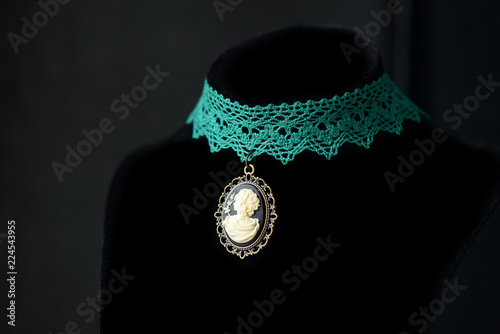 Choker necklace with girl cameo pendant on a dark background close up