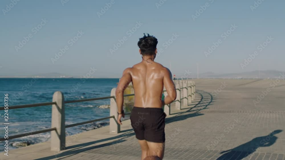 fit muscular young man running cardio jogging intense workout fit athlete enjoying endurance training on early seaside at sunrise slow motion