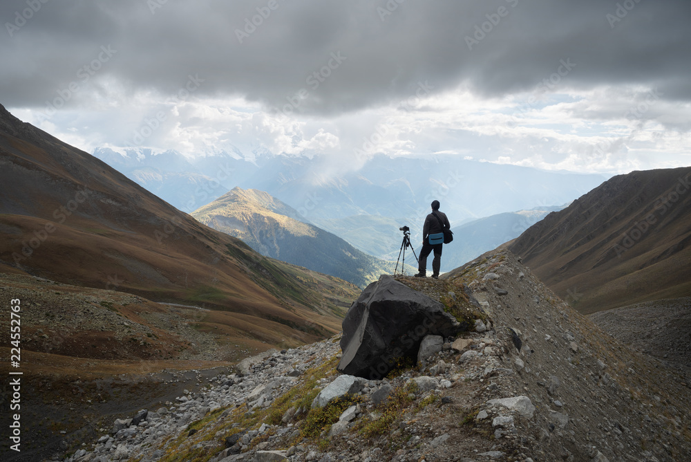 Fototapeta premium Photographer with camera and tripod in the mountains