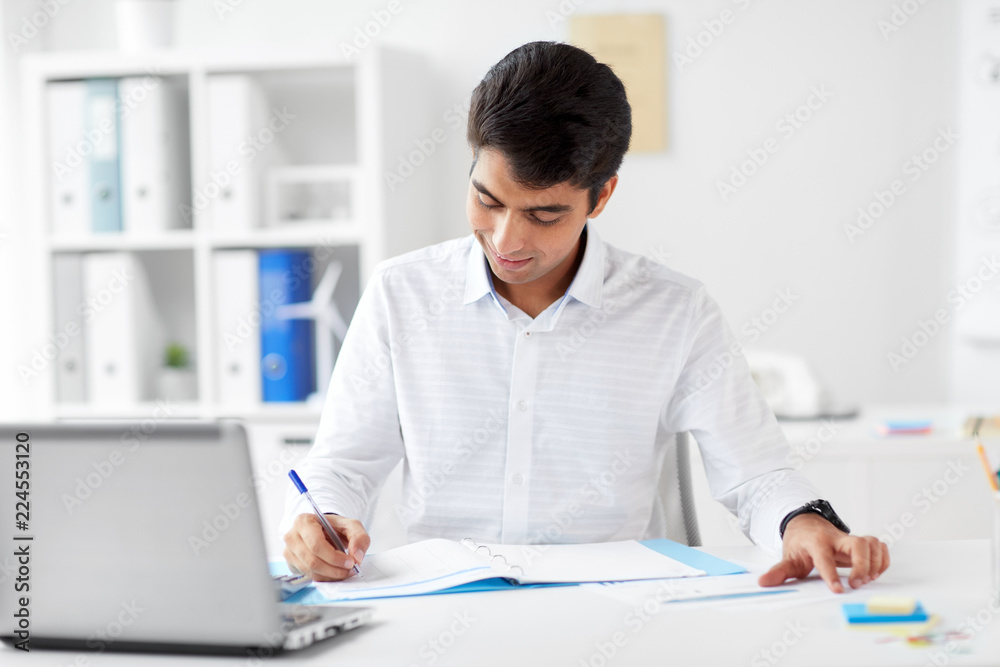 business and people concept - businessman with papers and laptop computer working at office