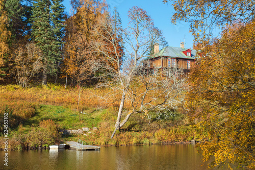 Beach with a jetty and a house on the hill in autumn
