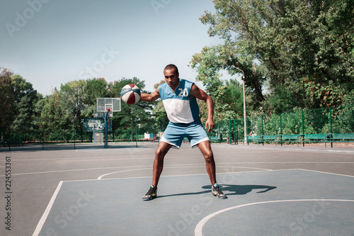 Picture of young confused african basketball player practicing outdoor. Fit afro man in motion and movement. athletic and sport lifestyle concept © master1305