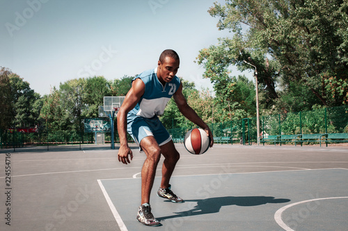 Picture of young confused african basketball player practicing outdoor. Fit afro man in motion and movement. athletic and sport lifestyle concept © master1305
