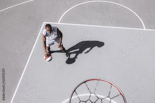 Picture of young confused african basketball player practicing outdoor. Fit afro man in motion and movement. athletic and sport lifestyle concept. Top view © master1305