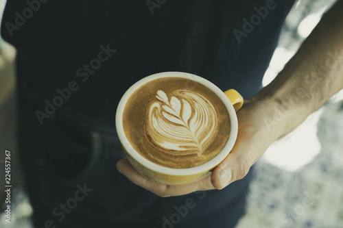 Barista hands holding coffee drink . Warm weekend.