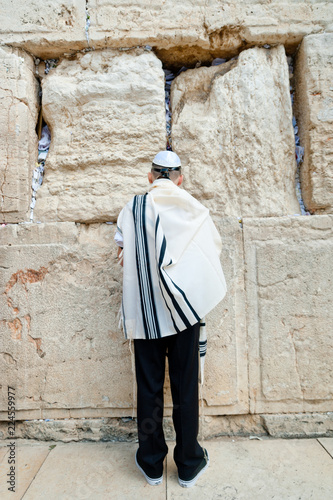 young jew boy praying near western wall in talit after his barmitzvah