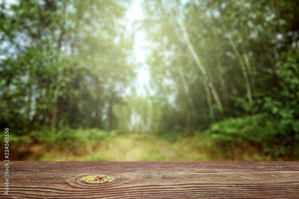 An empty wooden table overlooking a blurred green bokeh background, copy space for your text. Creative background, place for installation. Nature concept An empty wooden table overlooking a blurred green bokeh background, copy space for your text. Creative background, place for installation. Nature concept
