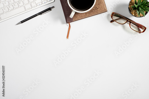 Workspace with computer, colour pencils and coffee mug on white background. Flat lay, top view