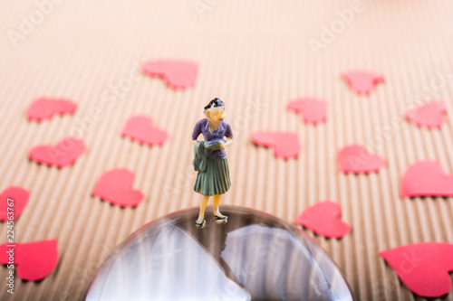Canvas Print Woman figurine on half a globe with paper hearts