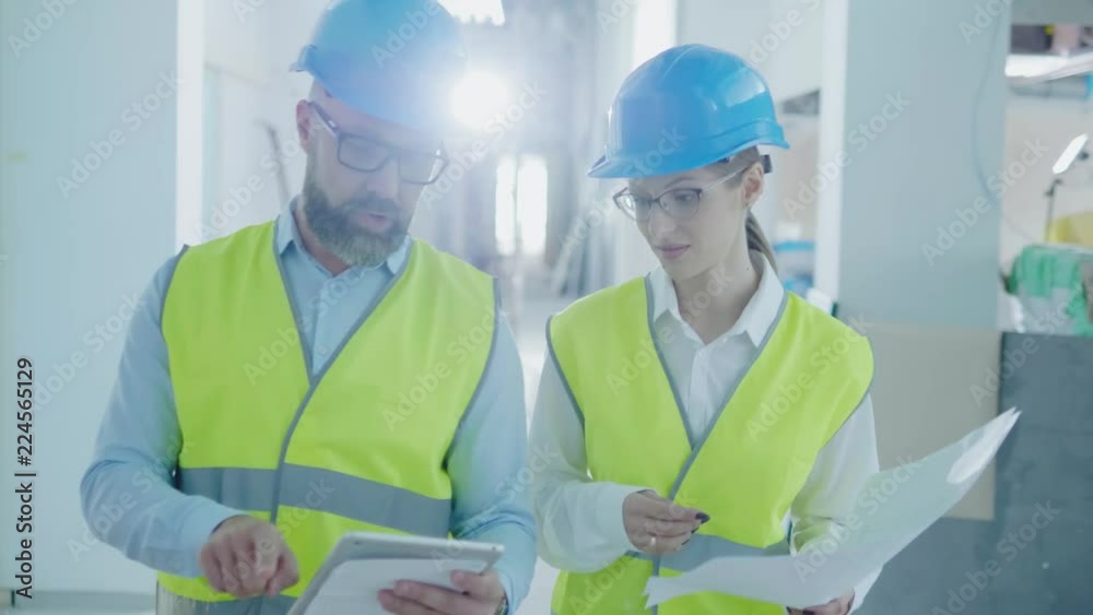 Engineers in hardhats have conversation Engineers in hardhats have conversation