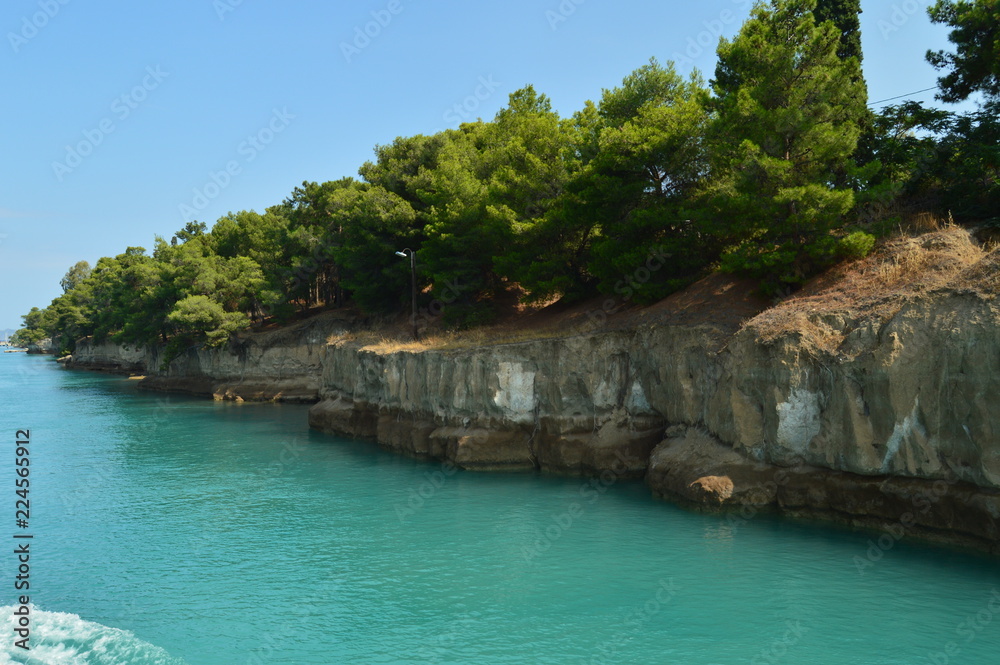 Nice Greenish Blue Tone Of The Sea United To The Molten Limestone Rock In Some Beautiful Rays Of Sun By Canal De Corinto. Architecture, Travel, Landscapes. July 8, 2018. Corinth Canal  Greece.