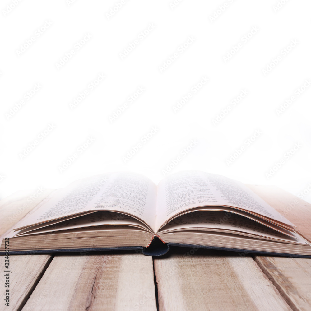 Educational concept. Opened book on wooden table against white background Educational concept. Opened book on wooden table against white background