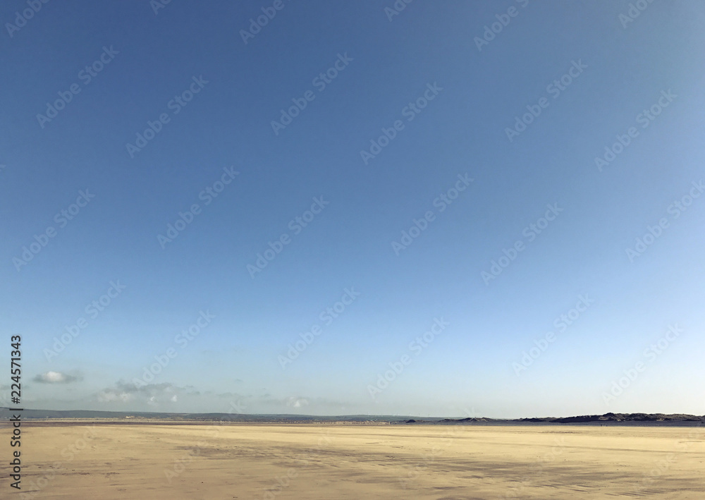 Calm English seaside. Flat sand and blue sky