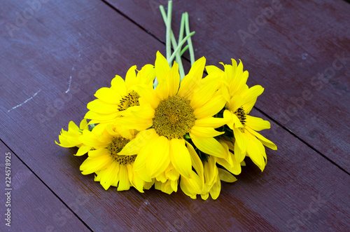 Fototapeta Naklejka Na Ścianę i Meble -  A bouquet of bright sunflowers on a wooden table