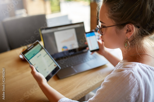 Photography Mixed race woman in glasses working with multiple electronic internet devices