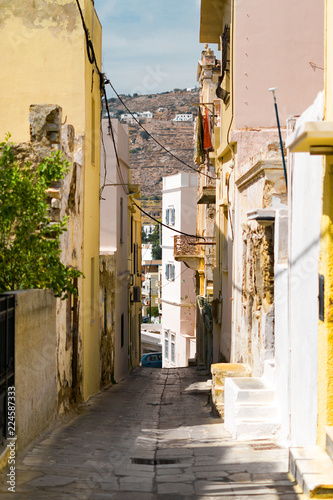 Fototapeta Naklejka Na Ścianę i Meble -  Сozy narrow streets of the old resort European town in a summer sunny day. Low-rise buildings of local residents, small cafes and hotels. Ermoupolis town on Syros island, Cyclades, greece.
