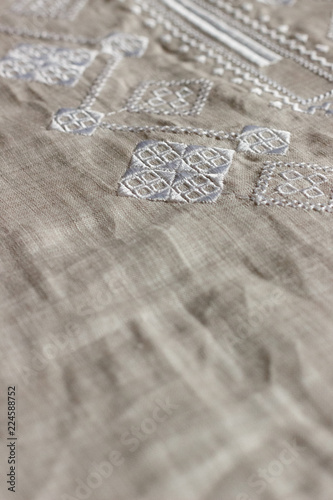 Fototapeta Naklejka Na Ścianę i Meble -  Embroidered linen shirt, white ornament, close