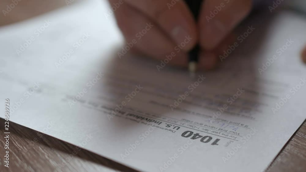 Man filling US tax form. tax form us business income office hand fill concept. Closeup.  Man Is Checking The Box Of Filing Status In The US Individual Income.  Tax Return Form 1040